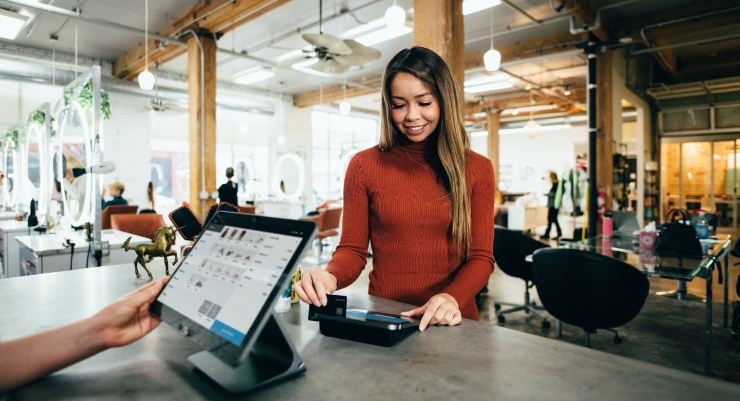 women at point of sale checkout with card