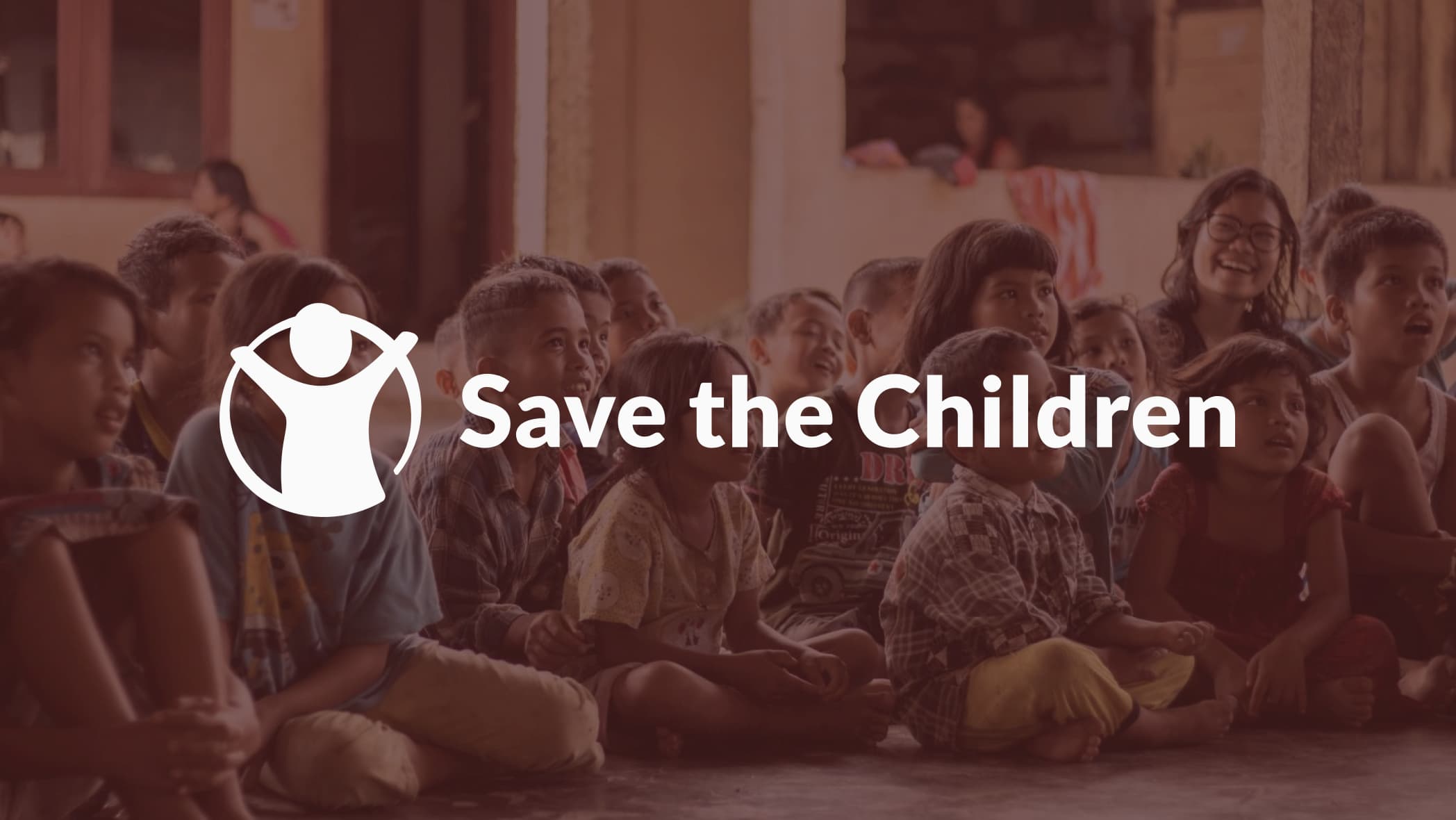 Save The Children logo with children sitting in background